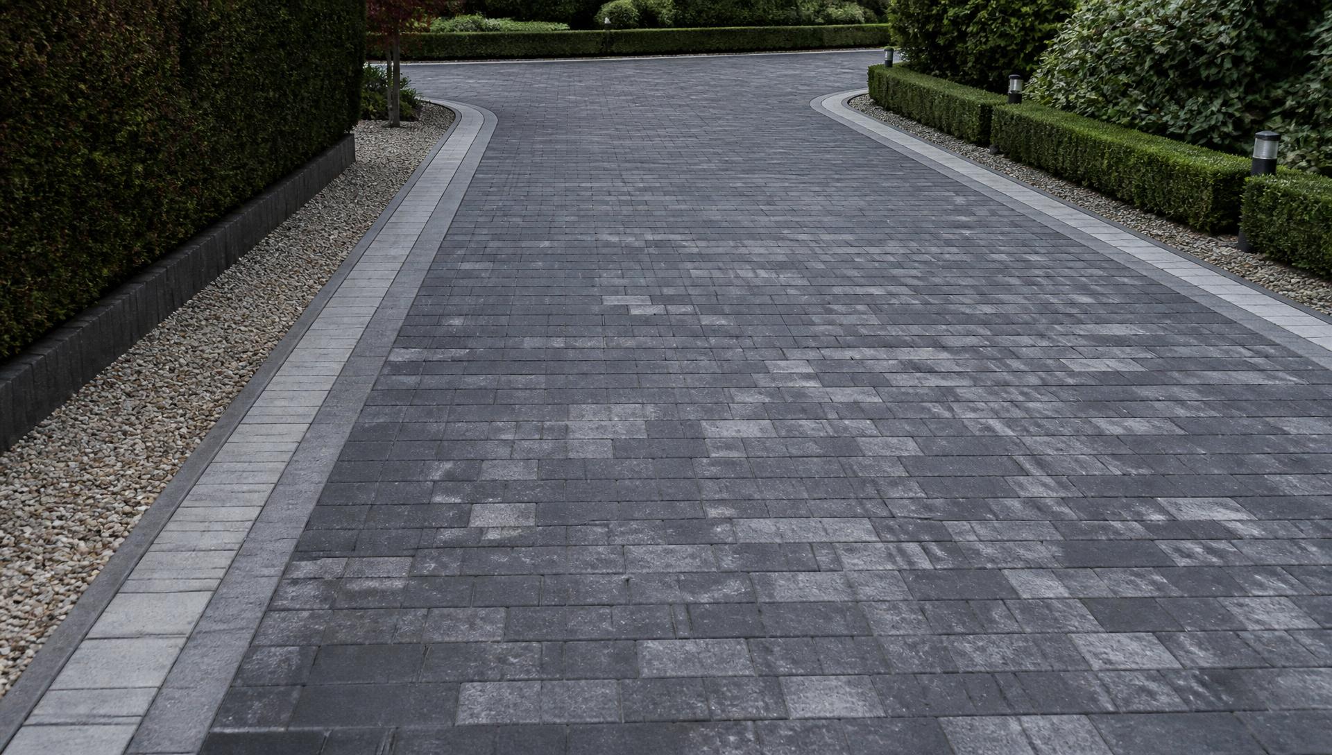 Freshly finished charcoal block paved driveway with contrasting border in daylight